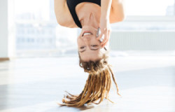 Upside down view of happy pretty young woman with dreadlocks tal